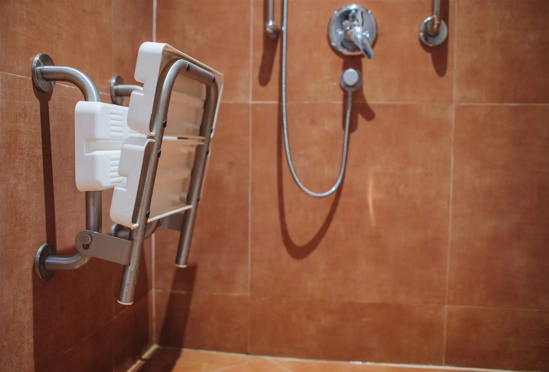 Bathroom shower with built-in seating, grab bars, and easy-to-reach controls