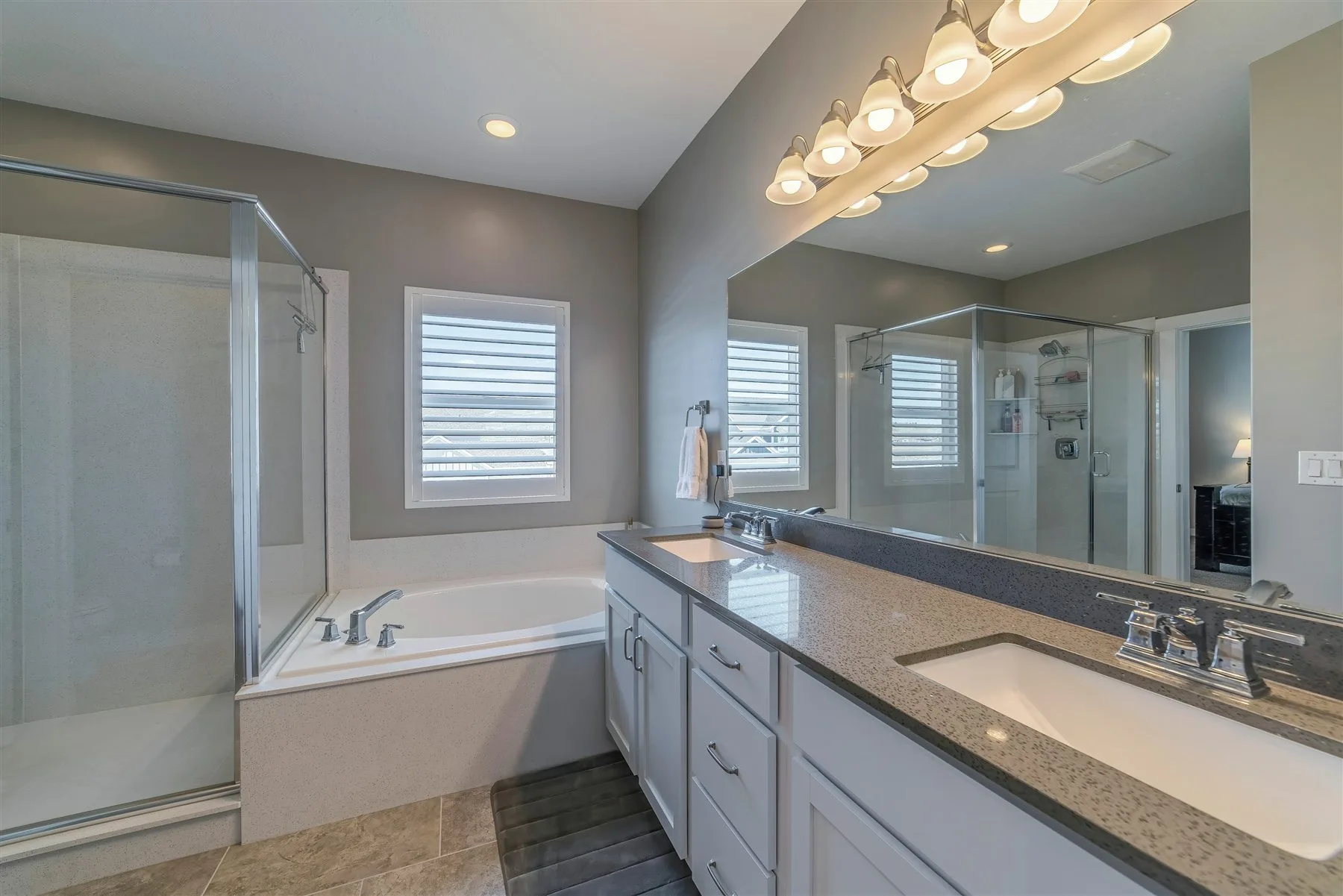 Double bathroom vanity with layered mirror and ceiling lighting