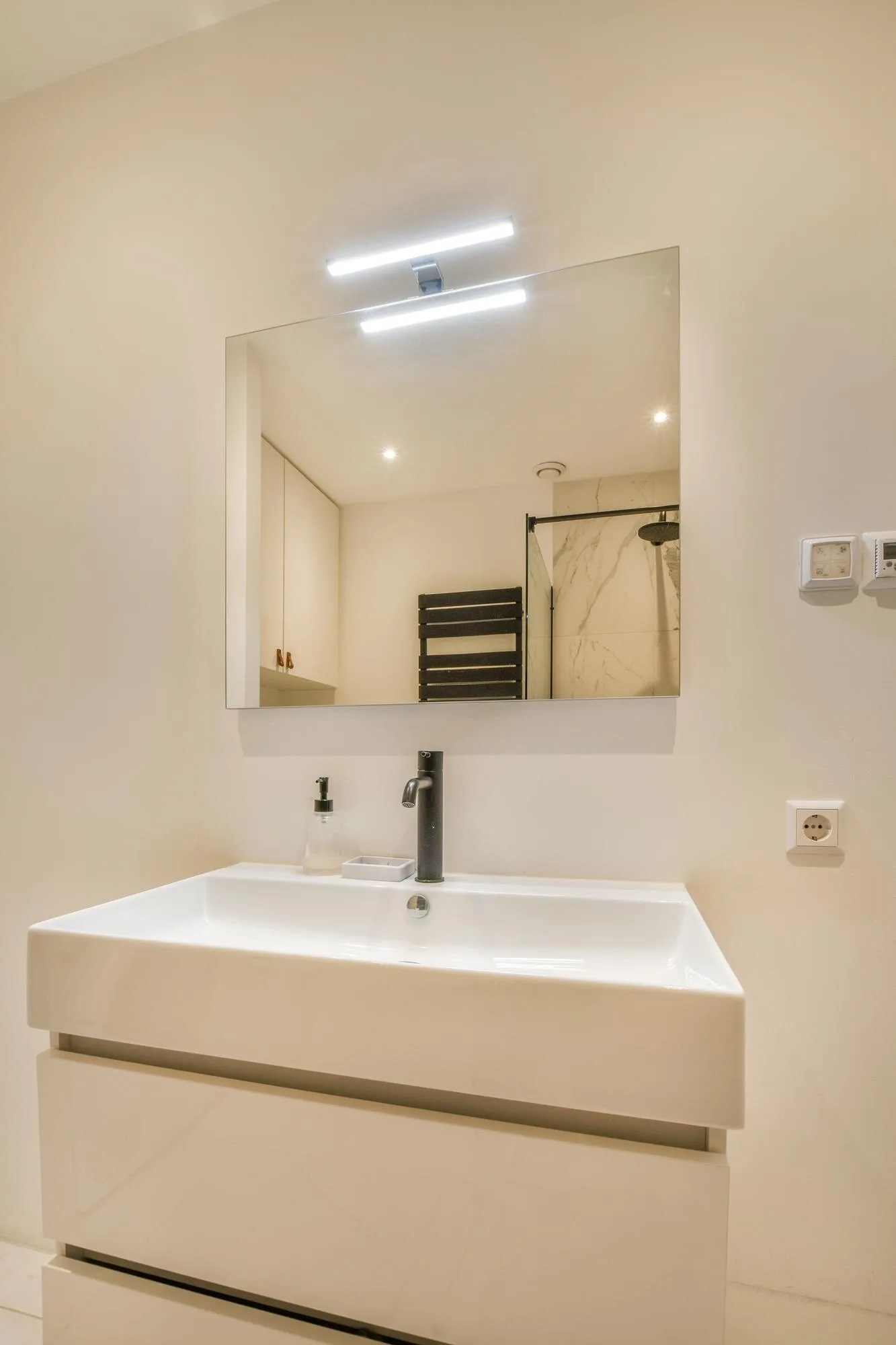 Simple residential vanity with a mirror light and natural wall illumination