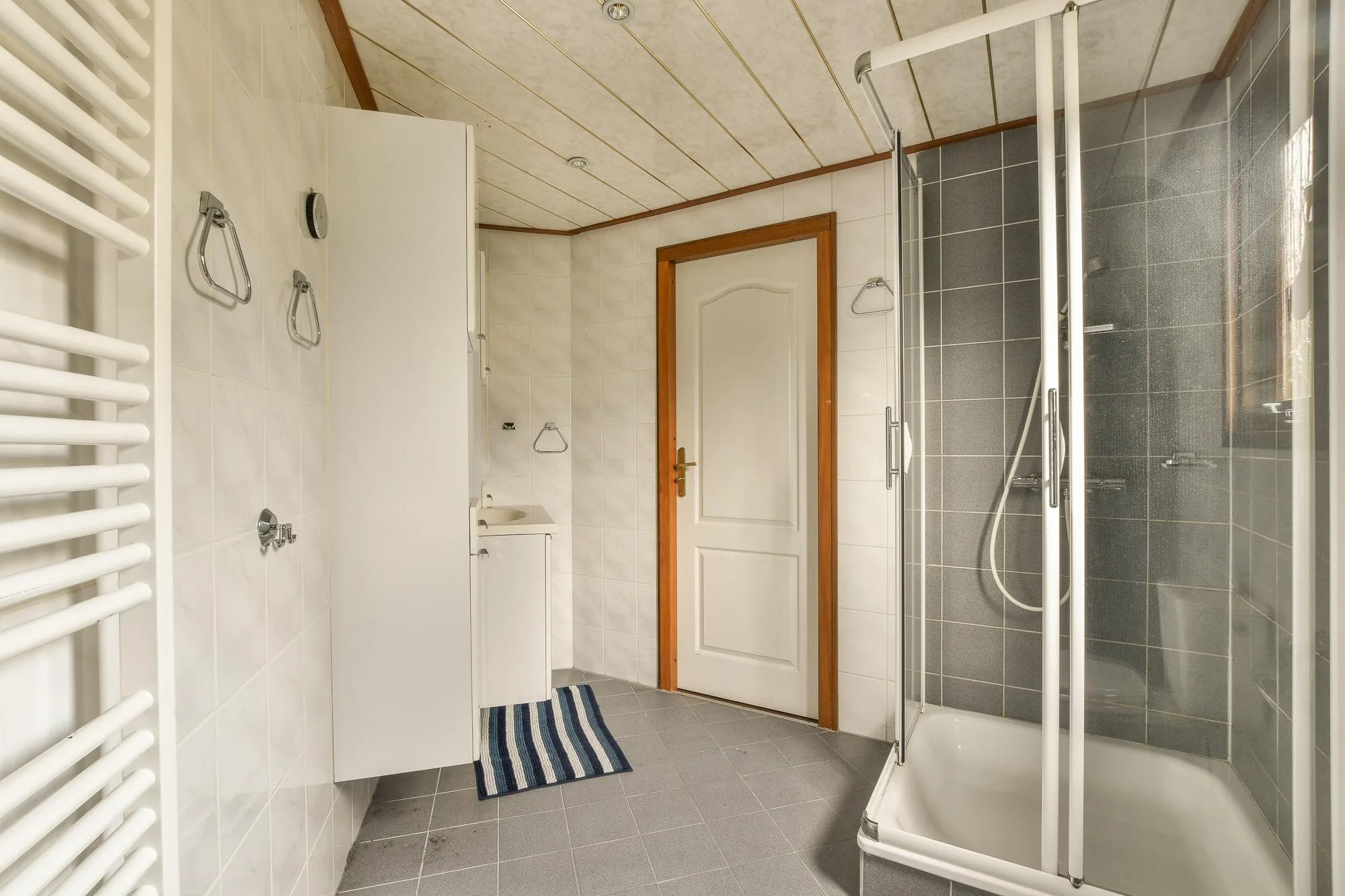 Compact residential bathroom with a glass shower enclosure and everyday fixtures